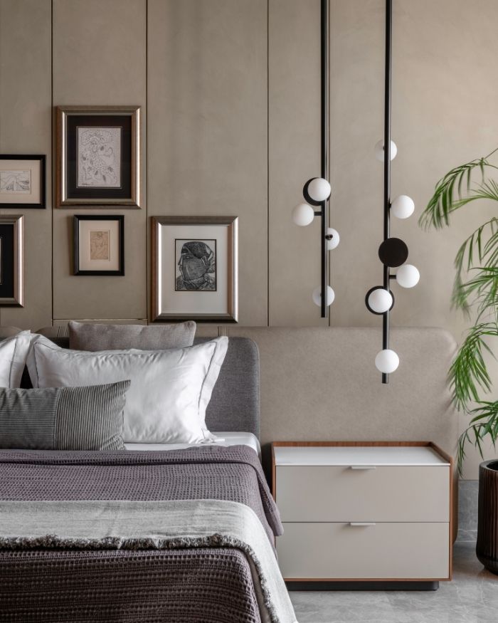 This bedroom hosts eclectic artwork beside a contemporary light fixture by Rakumba Typography Vela Series, with a custom bed and side tables; Styled by Sakshi Pathak; Photography by Photographix