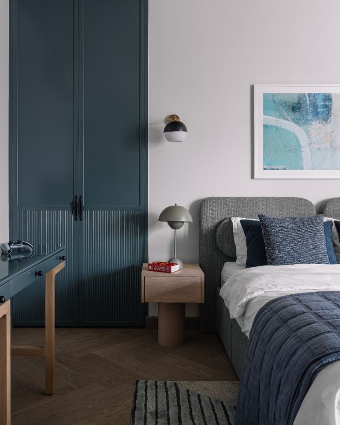 A discerning choice of matte teal joinery with fluted panelling lends warmth and subtle contrast in equal measure to the space. The artwork is from Calcuttan, table lamp by The Living Influence, furniture and millwork by DeMuro Das, and the rug is by Jaipur Rugs; Photography by Ishita Sitwala