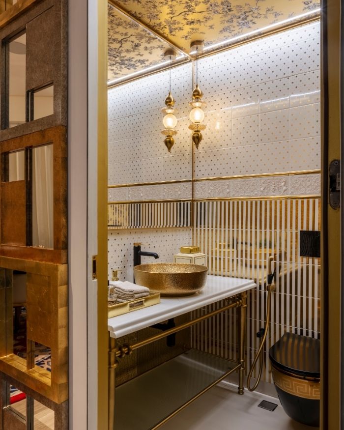 The powder room boasts a gold finish and sanitary ware from Kohler and Toto; Photography by Prashant Bhat