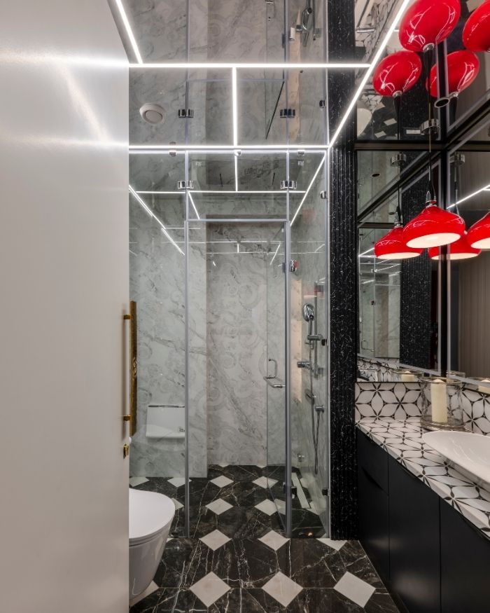 A bold bathroom, accents of red complement a floor of white and black marble; Photography by Prashant Bhat
