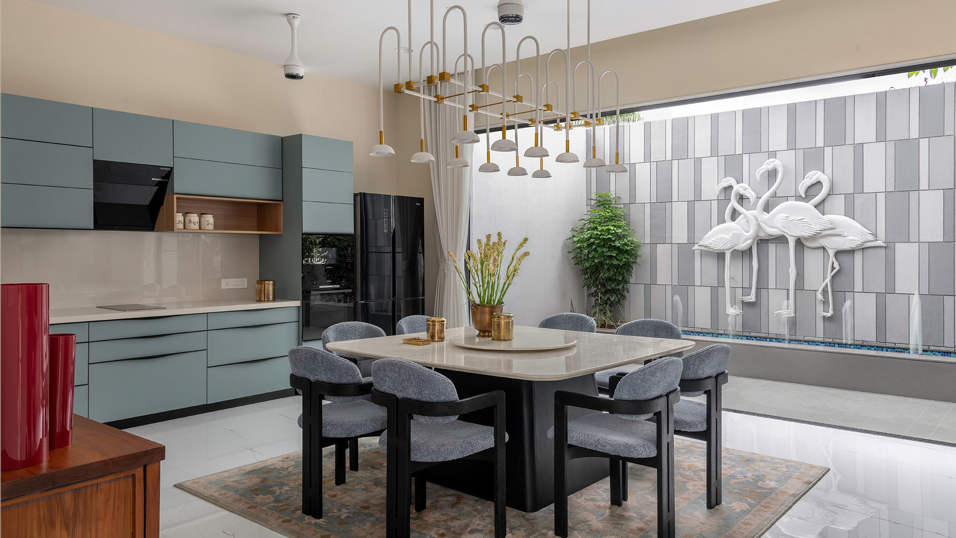 Flamingo Relief on tiled wall and a marble dining table at the centre with upholstered grey chairs
