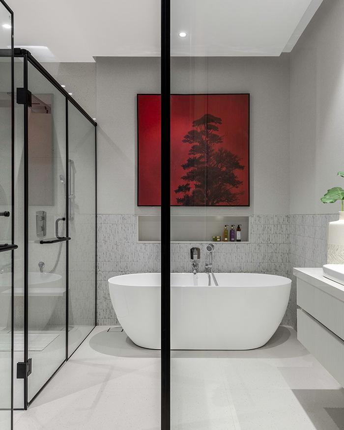 A freestanding tub and red artwork stands as the highlight
