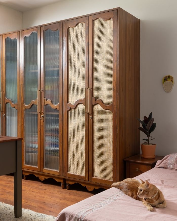 The family cat takes rest in the study room featuring a rug from Carpet Kingdom and a wood and cane cupboard; Photography by Roshan Sathish Paliath