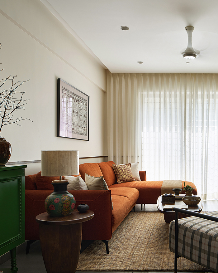 A custom sofa by Sanjar Furniture paired with tables from Urban Ladder. The green console and TV unit are custom-built complemented by a table lamp from Fabindia Homes and a textured rug from IKEA;Styling by Amol Nalavade; Photography by Manthan Yadav