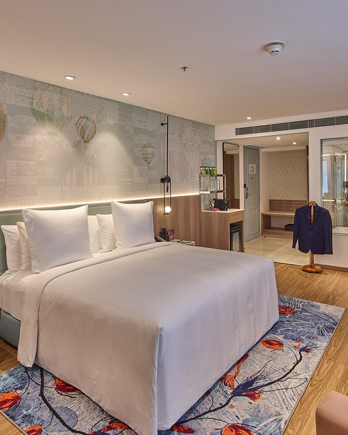 A comfortable room paired with wooden floorings and playful rugs crafting a calm retreat