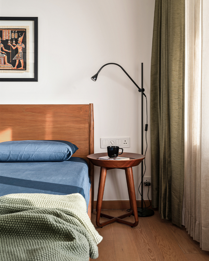 A beautiful teak bed by Vernacular Modern sits in the bedroom; Photography by Nayan Soni