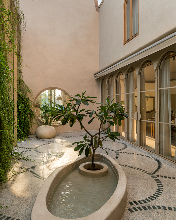 A large gate of framed metal doors enveloped with green planters forms the entrance of this home; Photography by Elmer S D’Souza and Abhijit Parsekar, The Photoarchitects