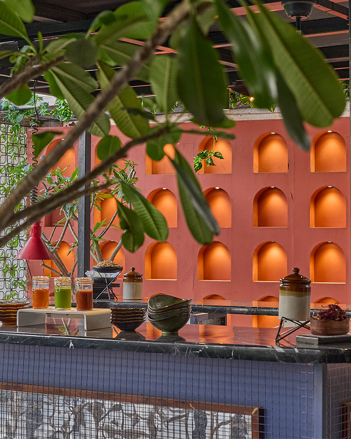 A counter set against a red Indian wall with arched carvings becomes the centre of focus