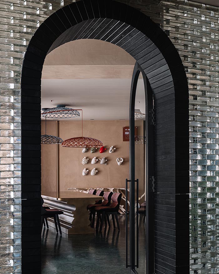 A wall with glass blocks
define the entry to the dining space.
The heart sculptures on the wall are
by Elica Design Studio; Photography by Ishita Sitwala