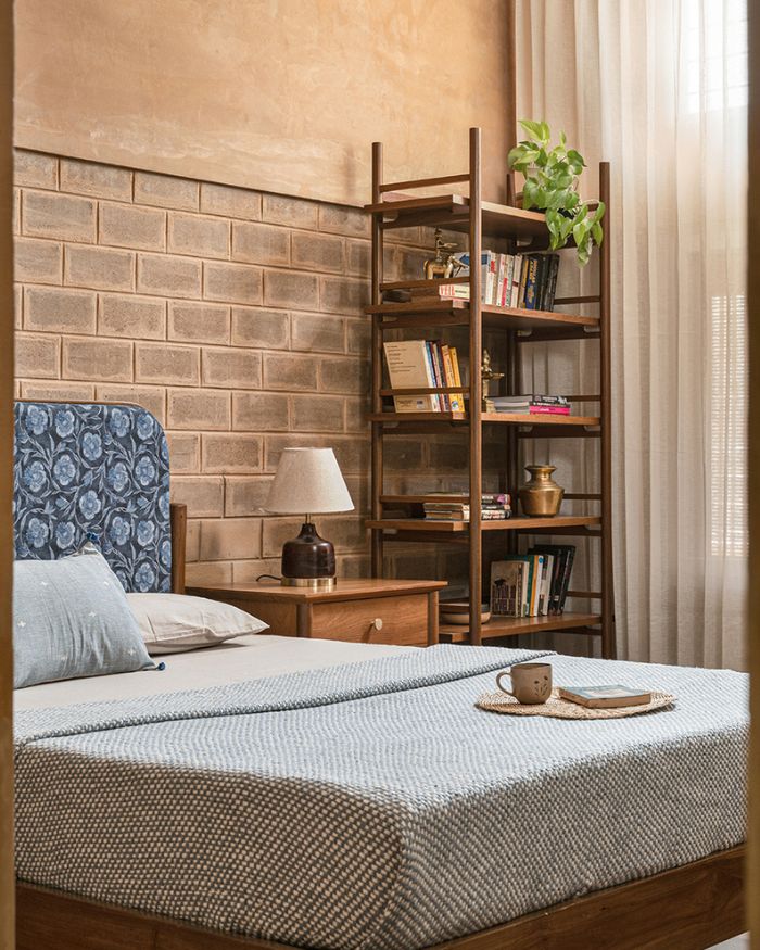 In the master suite, each piece of furniture — bed, bookcase, nightstands — is intentionally picked for flexible mobility and lightness. The cushions are from Minimal Indian; Photography by Nayan Soni