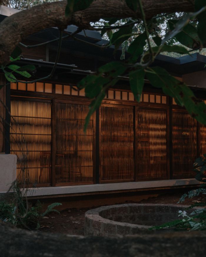 The old well anchors the courtyard, quietly reflecting light from the timber screens; Styled by Imran Ali Khan and Rishad Patel; Photography by Shantanu Starick