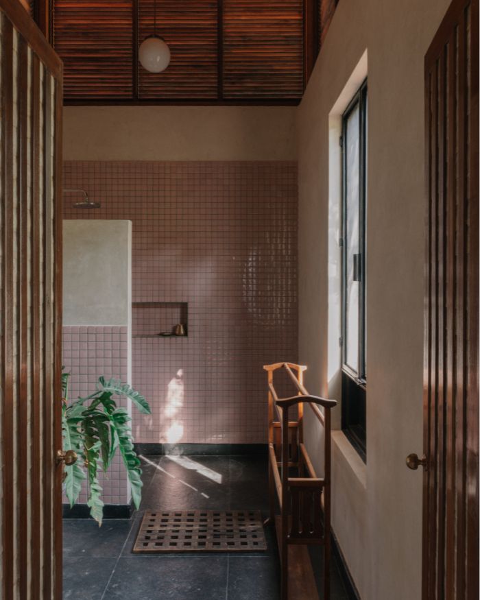 The guest bathroom pairs wooden screens with tiled walls and soft daylight; Styled by Imran Ali Khan and Rishad Patel; Photography by Shantanu Starick