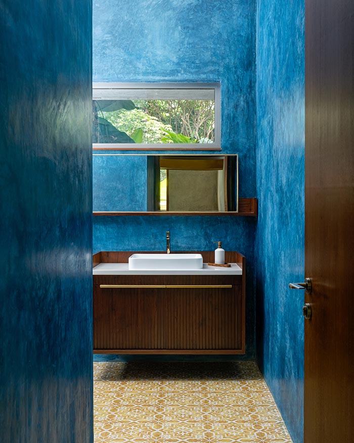 below; The
powder room features a
yellow patterned tiled floor and
indigo blue oxide walls; Photography by Shamanth Patil J