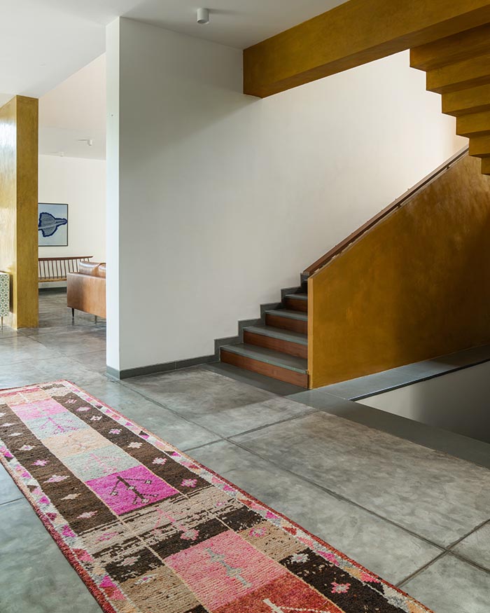 The staircase to the first
floor is finished in polished
yellow cement oxide, with
polished Kota stone treads
and teakwood risers. A Jaipur
Rugs runner in the foreground
anchors the composition; Photography by Shamanth Patil J