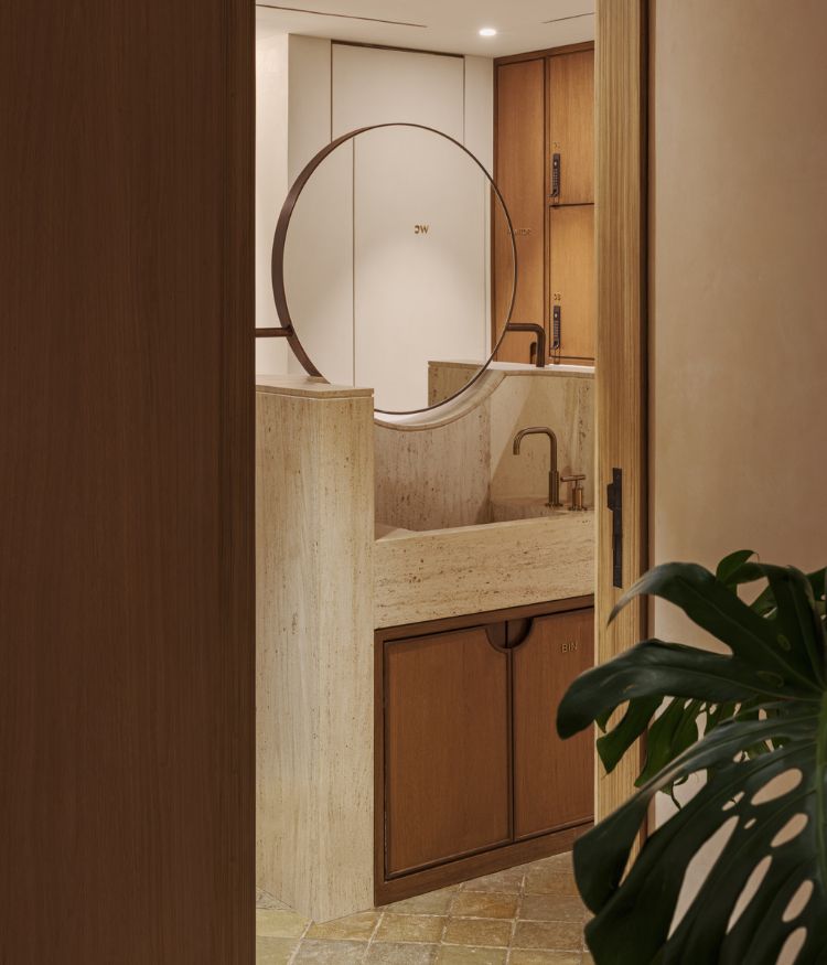 A stone-clad vanity features warm wooden detailing; Photography by Suleiman Merchant