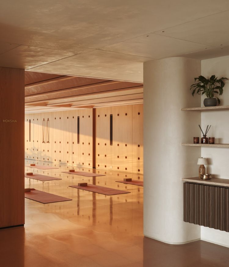 The yoga room is defined by red wood tones and sunlit hall; Photography by Suleiman Merchant