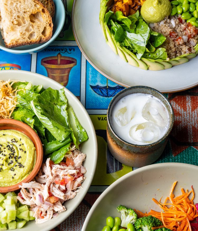 Brunch table with eggs benedict, sandwiches and coffee served in a bright cafe