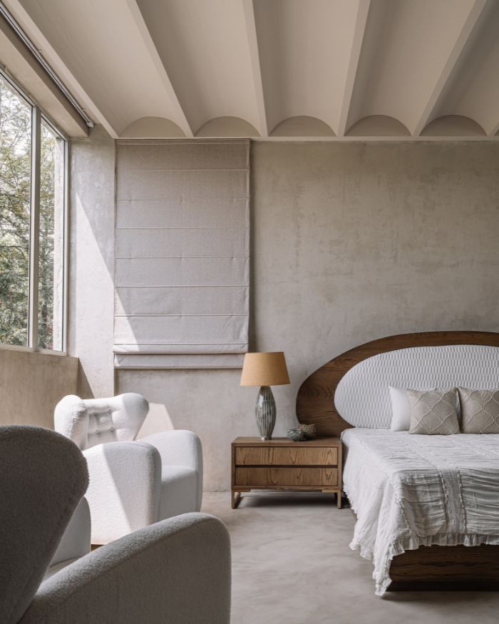In the bedroom,
the curves of the furniture play on the geometry of the vaulted ceiling; Photography by Ishita Sitwala