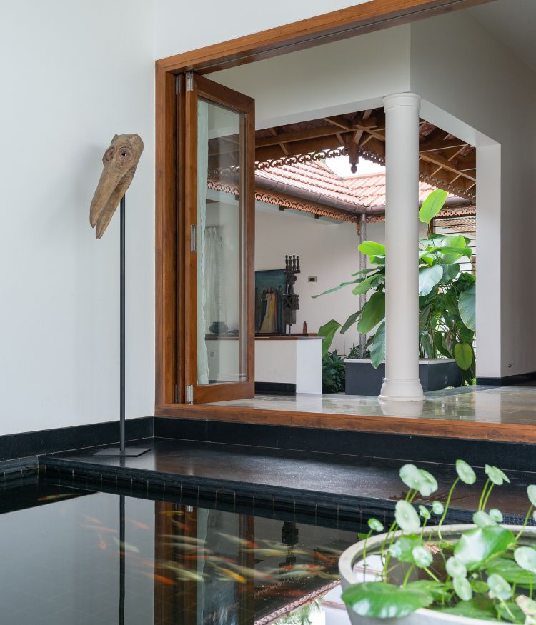 Leather-finished black granite from Kudky’s Stone Arch forms the koi pond, creating a spatial anchor that softens the blueprint; Photography by Syam Sreesylam
