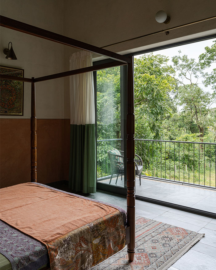 The bedroom spills out onto a balcony featuring hand-block printed curtains by Aruvi; Photography by Syam Sreesylam