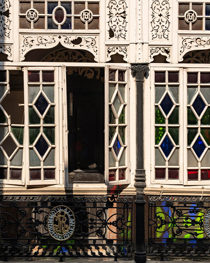 Patterned screens, stained glass segments and cast iron work choreograph the passage of sunlight, air and privacy through the home; Photography by Rohit Ganguly