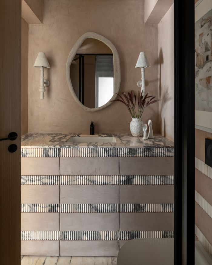 An amoebic mirror by Shailesh Rajput Studio sits atop the vanity which remains accessorised with a tabletop succulent by Eeshaan Kashyap; Styling by Riddhika Jesrani; Photography by @thekuber @evolve.studio_