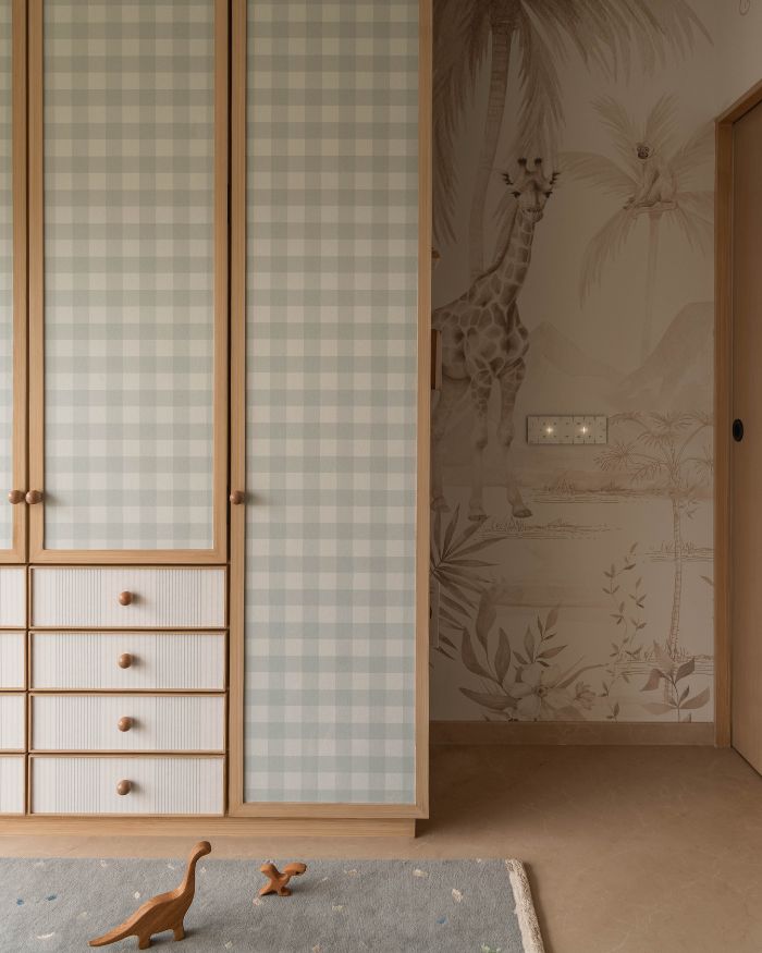 Soft blue checkered wardrobes make for a gentle visual element, beside the wild life themed wallpaper running across the room’s expanse; Styling by Riddhika Jesrani; Photography by @thekuber @evolve.studio_