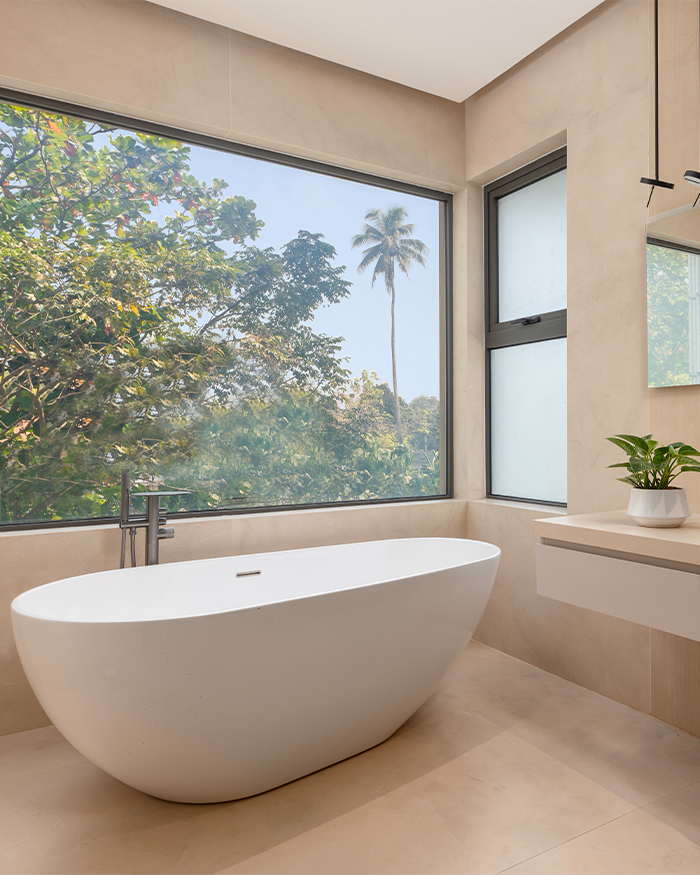 The master bathroom features bath fittings by Kohler and a cabinet by Lixil beside the freestanding tub; Photography by Sebastian Zachariah, PHX India