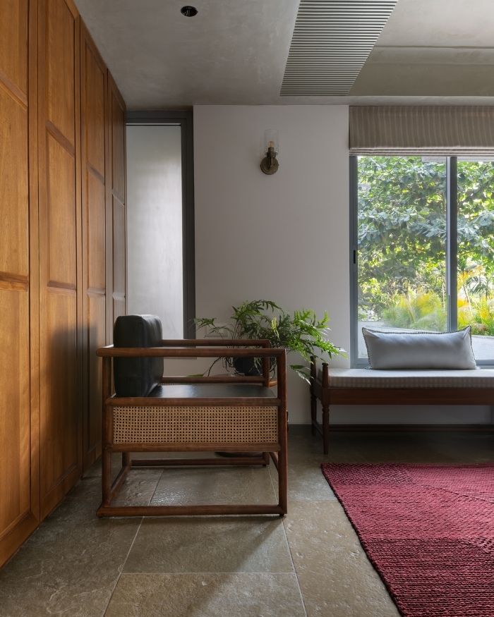 The interplay of timber, cane, lime plaster and textiles lends the corner a sense of warmth and lived-in comfort. Soft furnishings by Suta, Jaipur Rugs rug and lime finish by The Concrete Works; Photography by Hemant Patil