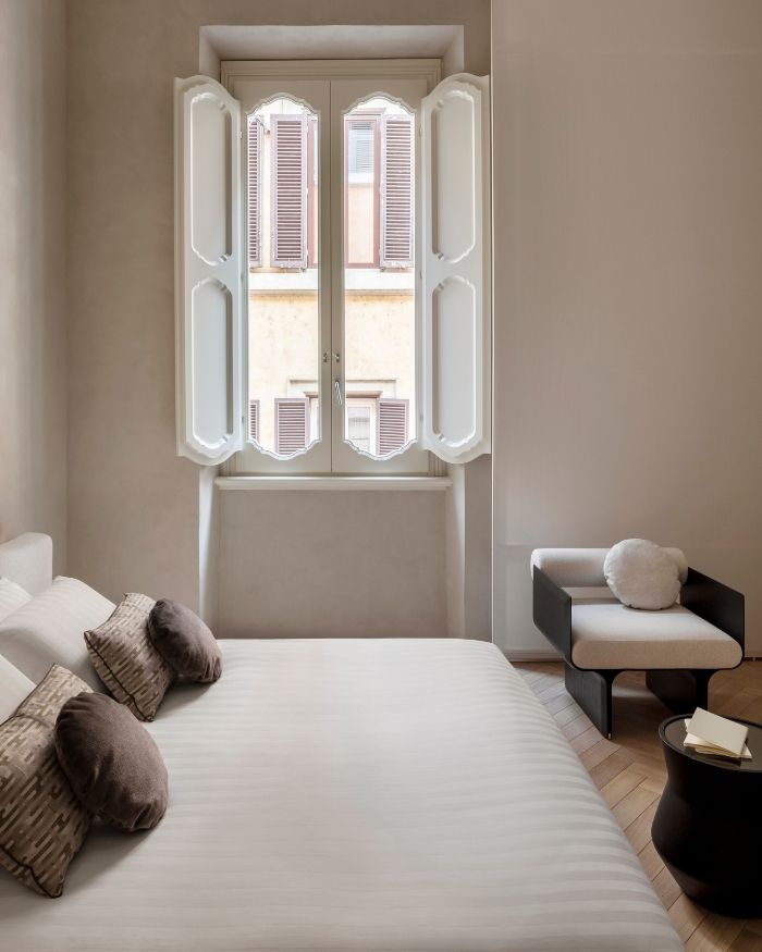 A carefully framed window draws the city into the room, while soft natural light and a muted palette create an atmosphere of quiet repose; Photography by Serena Eller of Eller Studio