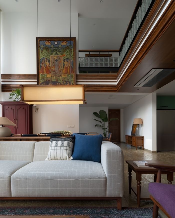 Anchored by a Pichwai artwork from Claome India, the living room brings together custom-designed furniture, handcrafted textiles from Junekeri Homes, and a rug from Contrast Living; Photography by Hemant Patil