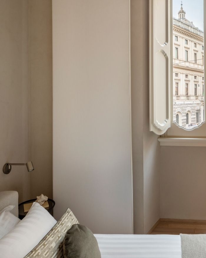 A carefully framed window draws the city into the room, while soft natural light and a muted palette create an atmosphere of quiet repose; Photography by Serena Eller of Eller Studio