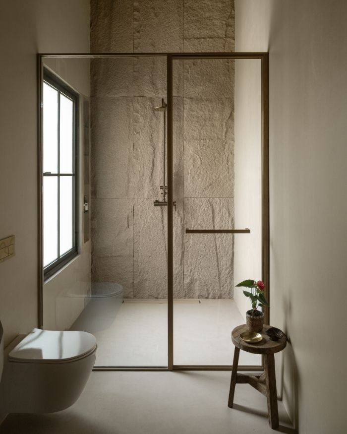 A minimal take on the bathroom, with microconcrete surfaces, a textured wall adding a tactile layer and bath fittings by Bathline Sensation India; Photography by Nayan Soni