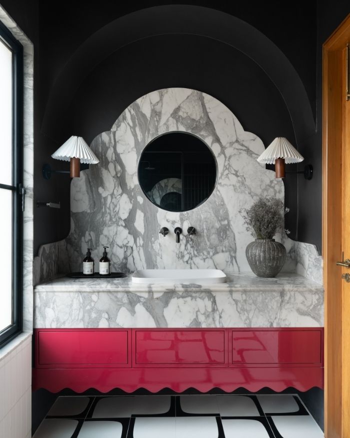 With a black backdrop, marble surfaces extend from the counter to the wall, adding a touch of colour alongside bath fittings by Bathline Sensation India; Photography by Nayan Soni