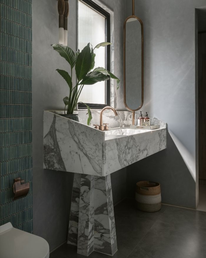 Microconcrete surfaces, KitKat tiles and a fluted glass window meet minimalist bath fittings by Bathline Sensation India; Photography by Nayan Soni