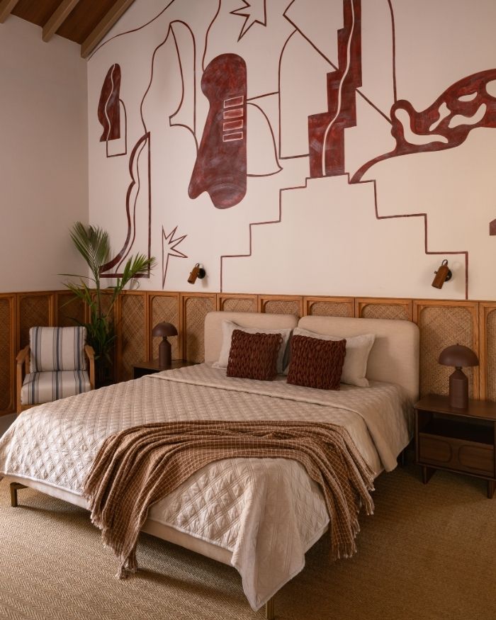 The guest bedroom features a striking red mural, with furnishings by Meher Sra Designs, lighting by The Living Influence and a bed by Altrove; Photography by Nayan Soni