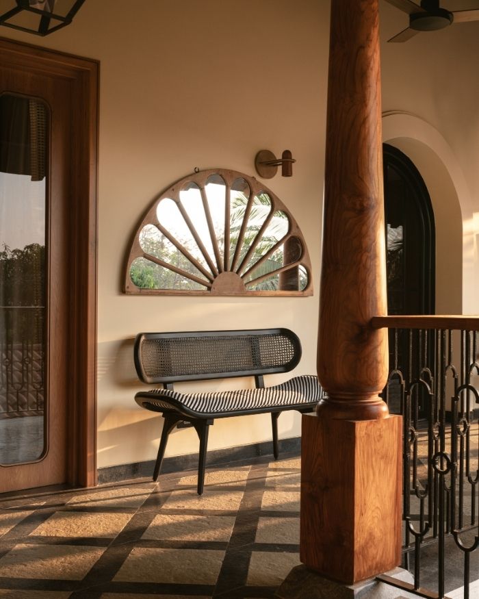 Passages open to the serene views of Goa, paired with a cane bench by The Living Influence and a mirror by Rangeela Goa; Photography by Nayan Soni