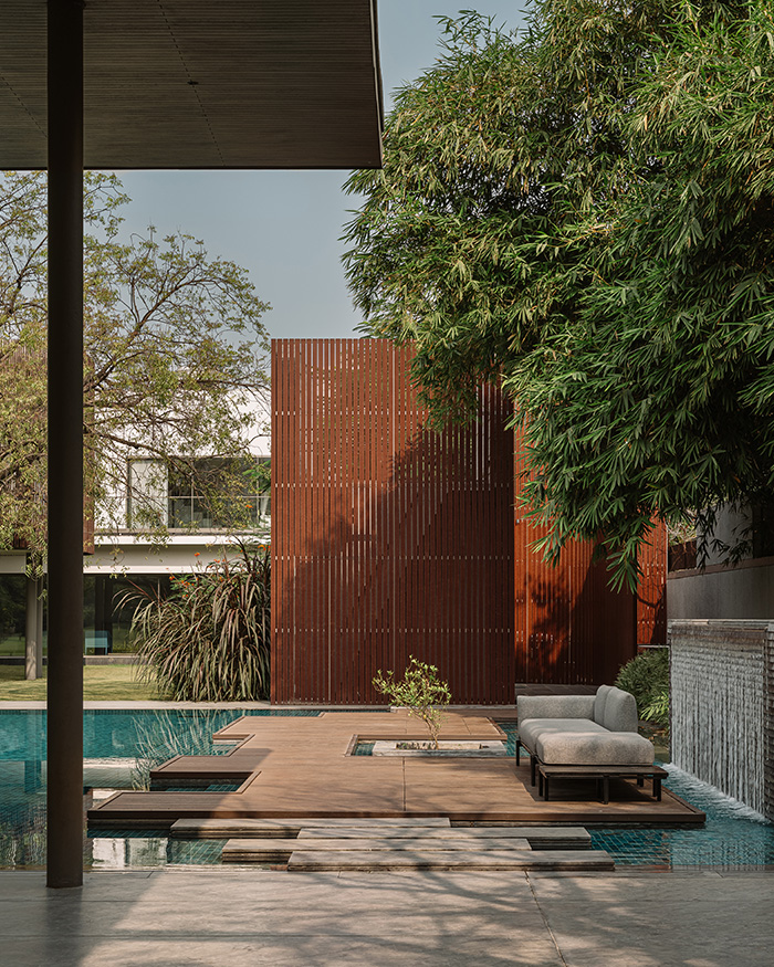A fountain, crafted with granite from Rock Studio,
gently trickles water at the side. A utility screen from Tipwood
lines one side of the deck, filtering light and adding privacy; Photography by Ishita Sitwala