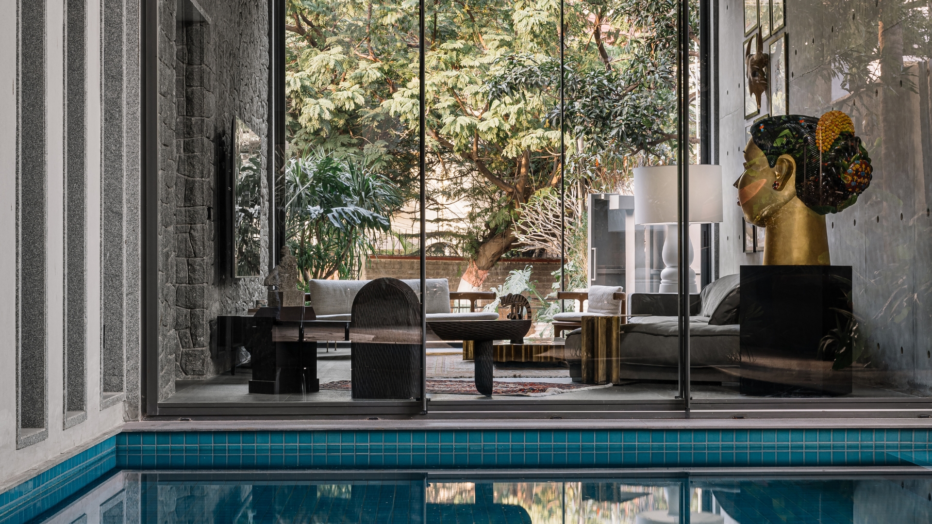 Looking from the outdoor pool, through the living room, and towards the entrance, the line of vision is directed by a series of spaces; Photography by Ishita Sitwala