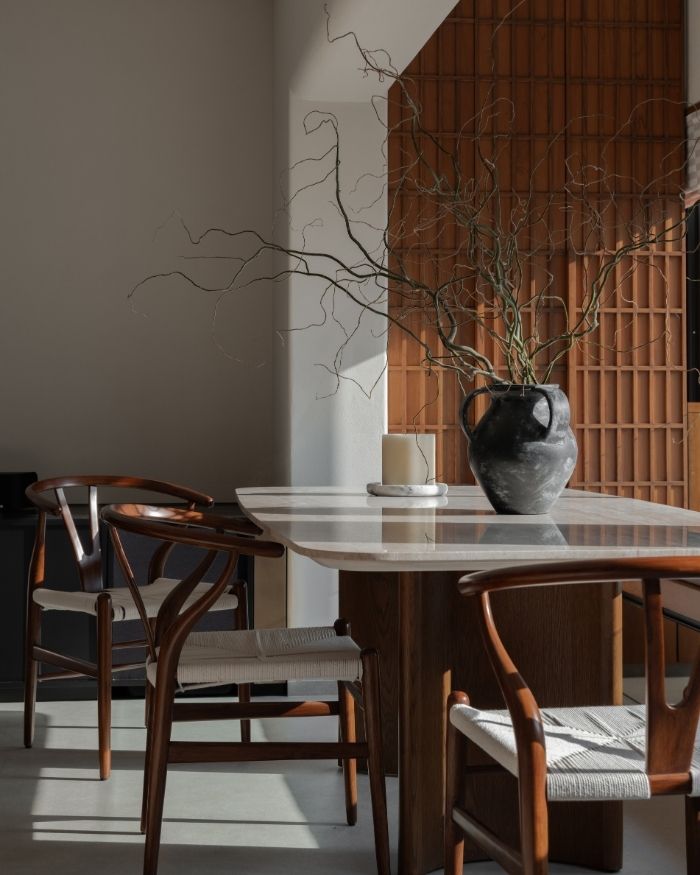 The custom-made window-side dining ledge is undoubtedly a standout element. The dining chairs are from Tianu, and the table is from Empire Living; Photography by Kuber Shah