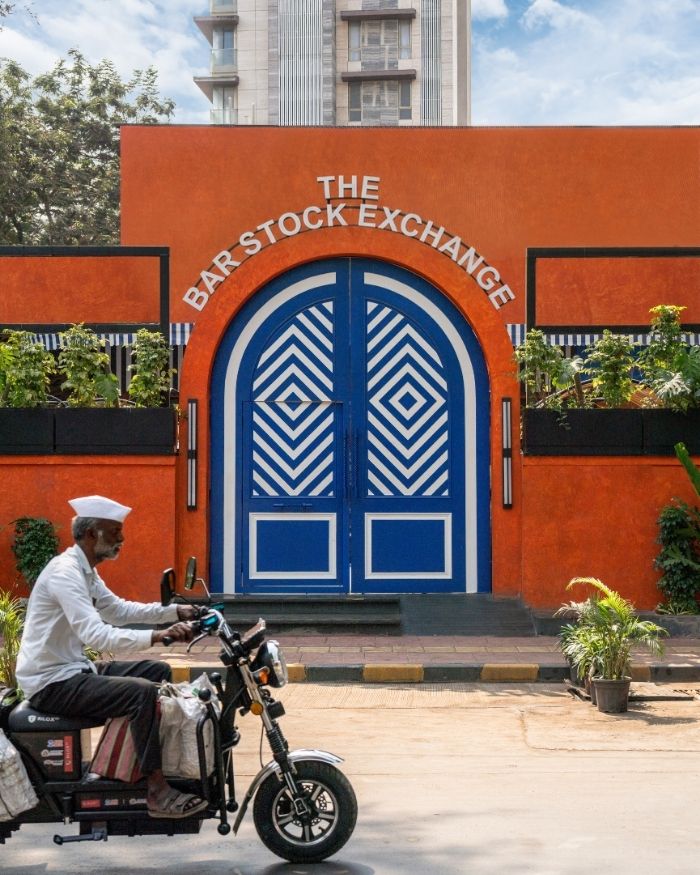 A vibrant and inviting entrance featuring a terracotta
orange facade with blue geometric double doors by KK Contractor instantly draws attention with its unique design and
lively colors; Styling by The Orange Lane; Photography by Kuber Shah