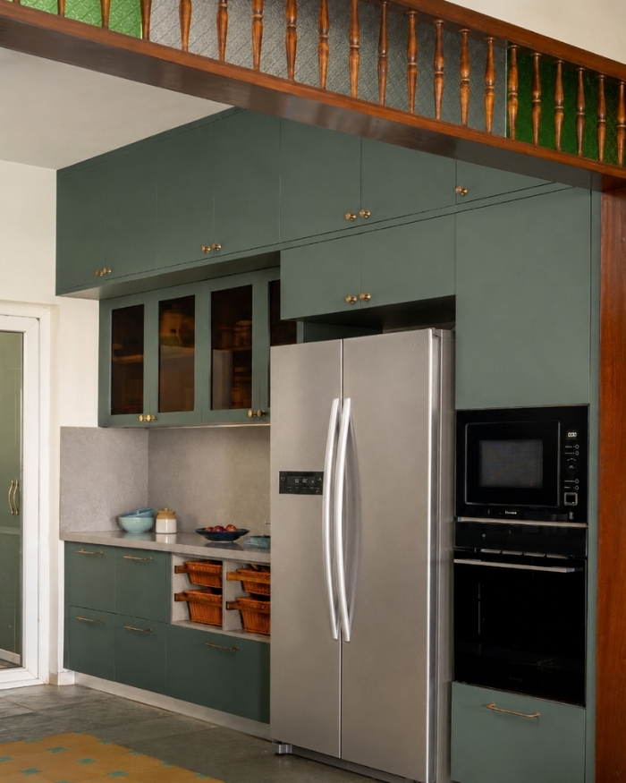 The modular kitchen, crafted in collaboration with Zenia Kitchens and Wardrobes, embraces a playful layering of colours and textures β Kota flooring embedded with Athangudi tiles, paired with deep green cabinetry; Photography by Shine Parsana