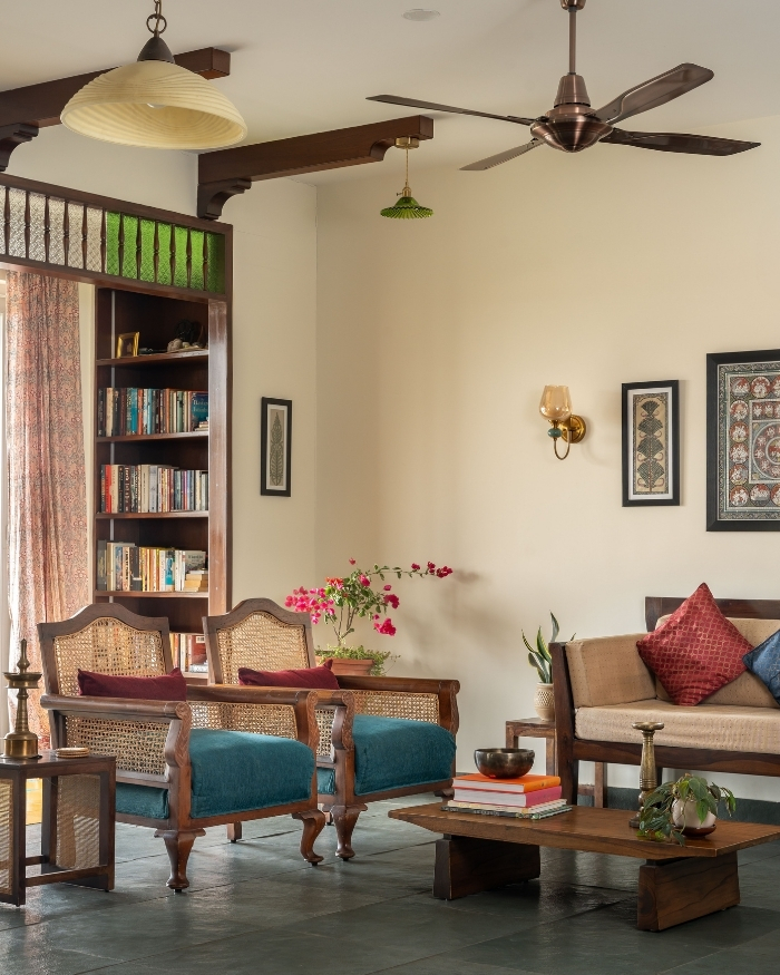 A reading alcove rests just behind the living area, the space marked out by a spread of Athangudi tiles underfoot and the lofty bookcase stacked with the coupleβs collection; Photography by Shine Parsana