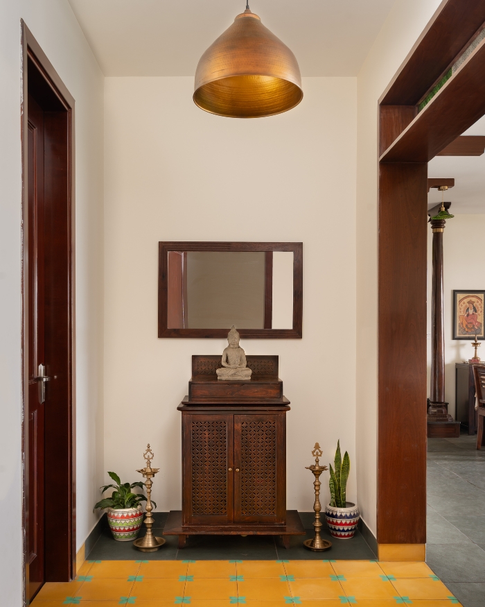 Athangudi tiles from Chettinad Tiles bathe the foyer in a bright yellow, patterned with a turquoise floral motif; Photography by Shine Parsana