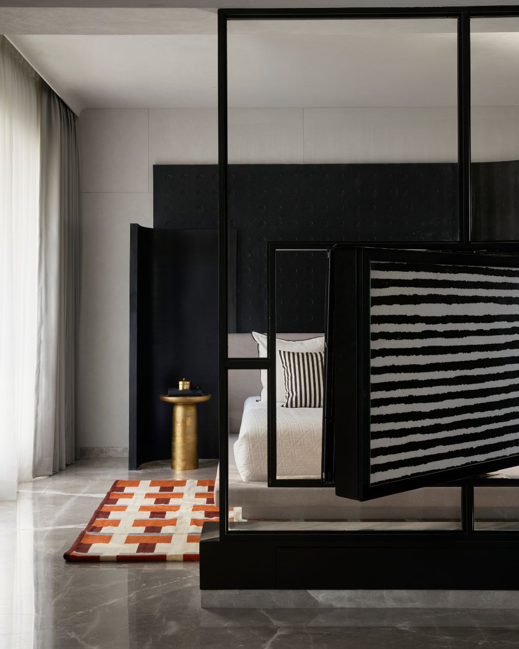 The primary bedroom consists of a feature wall and a black folding screen with a custom-made rug from Jaipur Rugs & Rugberry paired with accessories from H and M. Styled by Namrataa Shetty; Photography by Talib Chitalwala