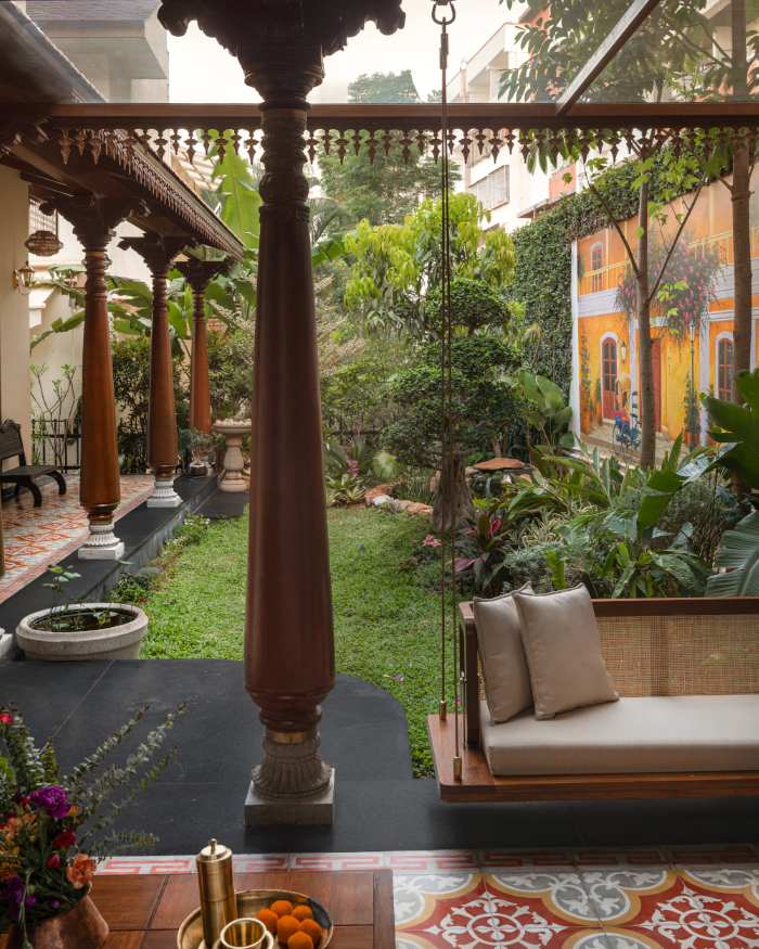 Ramesh Babu's mesmerising mural art perfectly frames Athangudi Palace Tiles flooring and traditional Karekudi pillars along a statement swing from Essentially Metal; Styling by Apoorva Nayak, Photography by Arjun Krishna