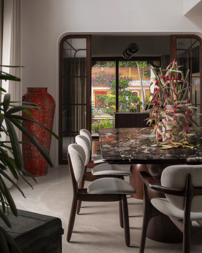 Tramo chair from Magari grounds the dining space, while a bespoke red vase from Curious Hues introduces an artistic contrast; Styling by Apoorva Nayak, Photography by Arjun Krishna