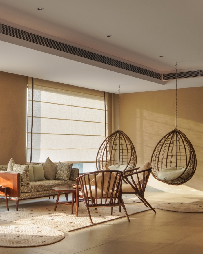 Two drop-shaped swings hang near a seating arrangement