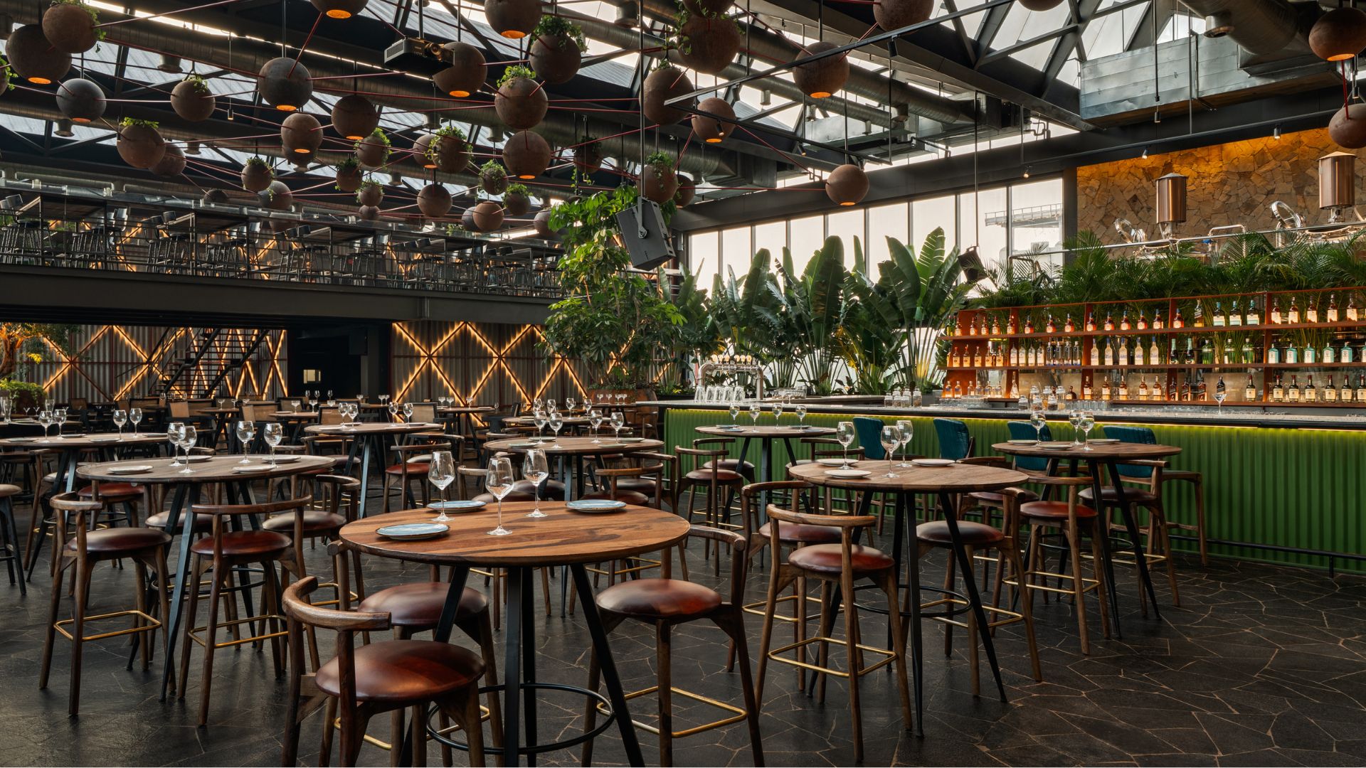 The bar appears as a playful counterpoint to the rest of the space, adding a wash of green across the counter and back lit panels for after dark