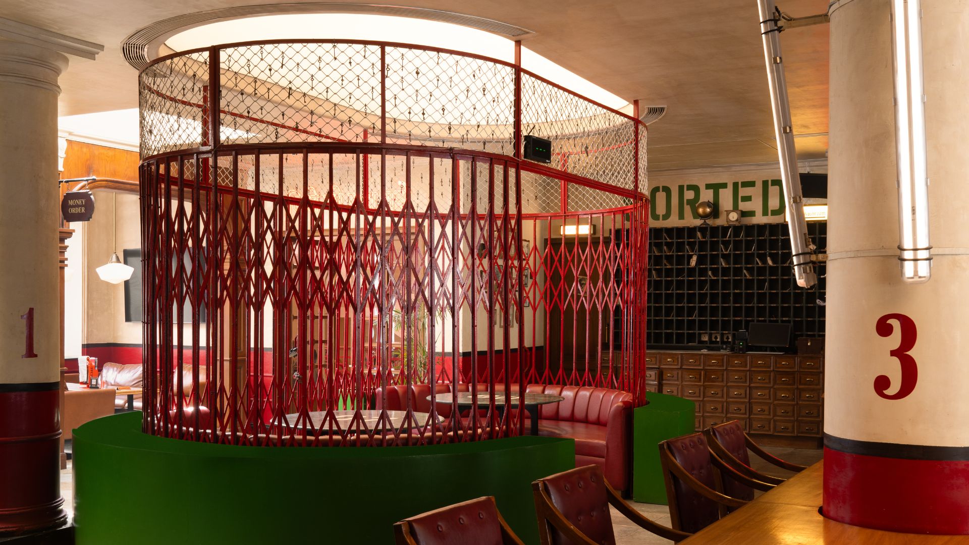 A circular private dining room wrapped in a bespoke red steel lattice reminiscent of collapsible security gates